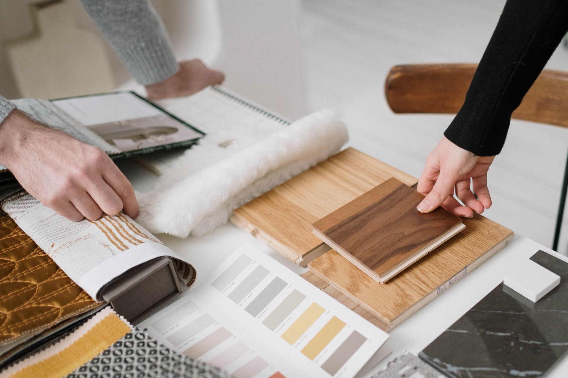 Hands comparing timber and textile samples in the studio's material library